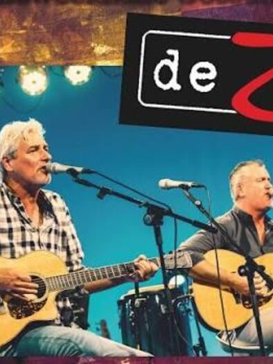 Die Musiker von deZwa singen auf der Bühne und spielen Akustikgitarre bei einem Austropop-Konzert in Gössendorf. | © deZwa