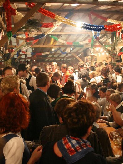 <p>The beer tent in Altaussee is a lively festival hall filled with many people celebrating together. Festive decorations and a cheerful atmosphere characterize the setting.</p> | © FF Altaussee