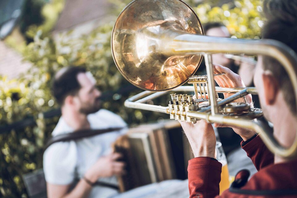 Musiker spielen Posaune und Akkordeon beim gemeinsamen Bradln in einem Buschenschank in Eggersdorf. | © Ulrike Rauch