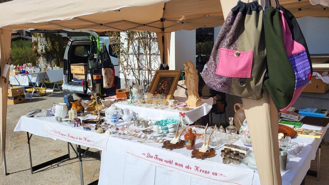 Ein Flohmarktstand mit verschiedenen Antiquitäten und Sammelwaren. Darunter sind Keramiken, Gläser und Taschen zu sehen. | © Petra Kirchschlager