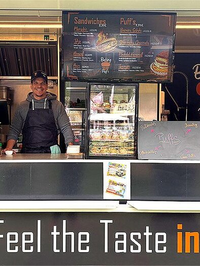 Koch hinter dem Verkaufstresen eines Foodtrucks mit Sandwiches und weiteren Speisen in Seiersberg-Pirka. | © foodandfunfestival.at