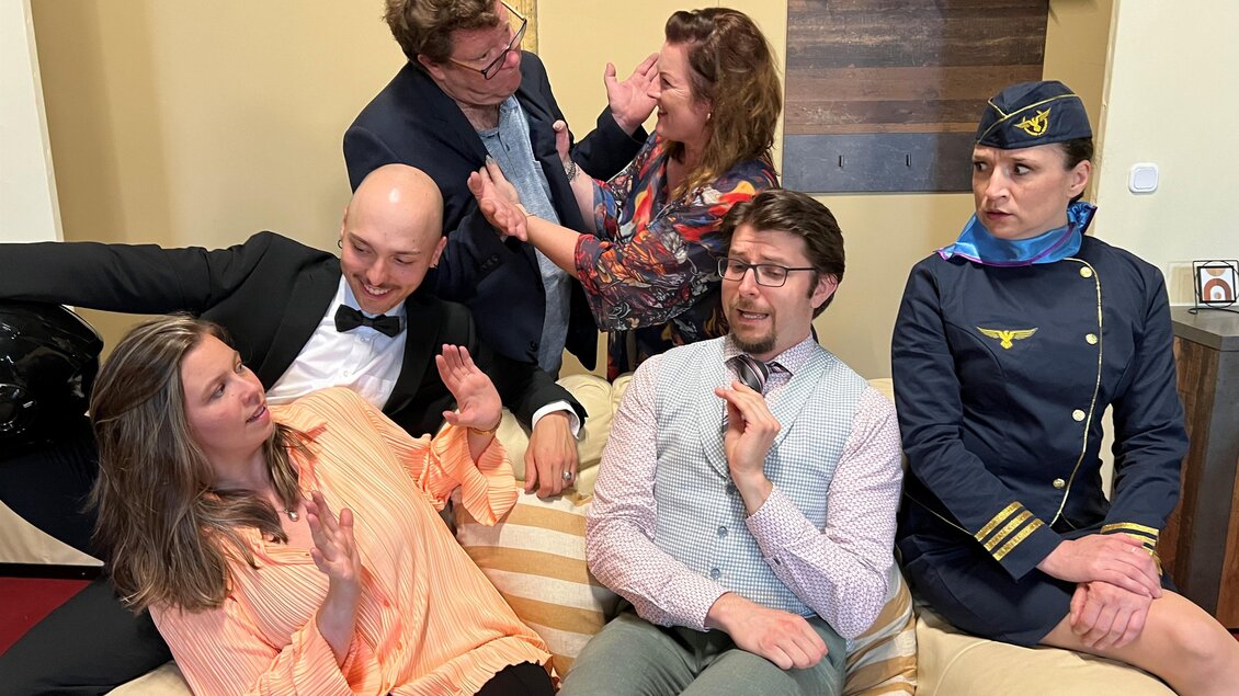 Sechs Darsteller in einer humorvollen Theaterszene auf einem Sofa beim Stück „Auf die Plätze, fertig, Lo..ve!“ im Hof des Steiermärkischen Landesarchivs in Graz. | © Susanne Malik