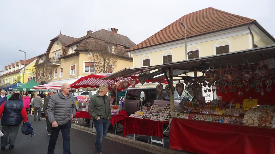 Ein Markt mit bunten Ständen und Besuchern auf der Straße. Es sind verschiedene Waren und Lebensmittel ausgestellt. | © Marktgemeinde Gnas