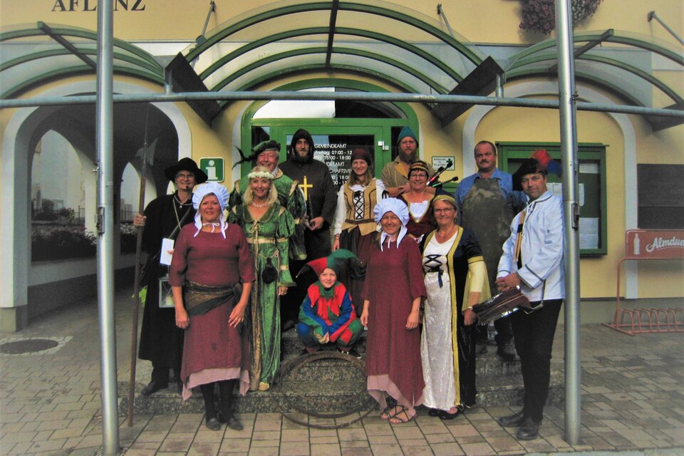 Eine Gruppe von Menschen in historischen Kostümen steht vor einem Gebäude. Sie lächeln und posieren gemeinsam für ein Foto. | © © Kurverwaltung Aflenz