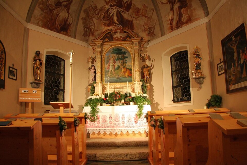 Eine kleine Kapelle mit einer beeindruckenden Altarwand und bunter Fresko-Malerei. Die Bänke aus Holz und die dekorativen Elemente schaffen eine ruhige, spirituelle Atmosphäre. | © Mares Rastl