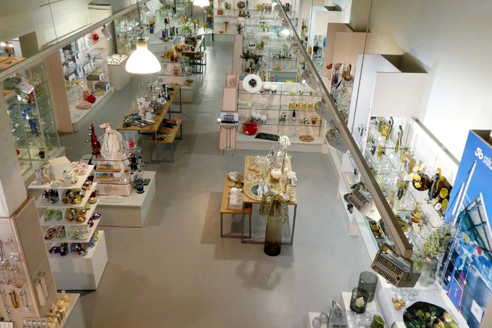 Ein moderner Verkaufsraum mit vielen Regalen voller Glaswaren und Dekorationsartikeln. Die Beleuchtung ist hell und der Raum wirkt einladend. | © Glasmuseum Bärnbach, Zvonka Pozun