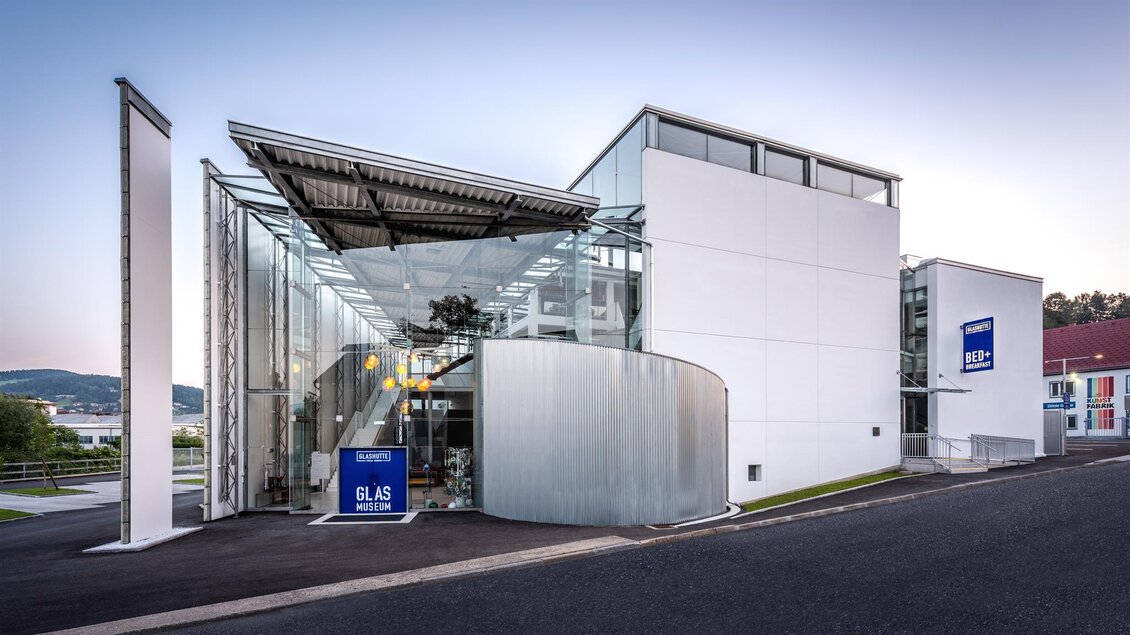 Ein modernes Gebäude mit gläserner Fassade und geschwungenem Design. Die Umgebung ist sauber und gut gepflegt. | © Die Abbilderei