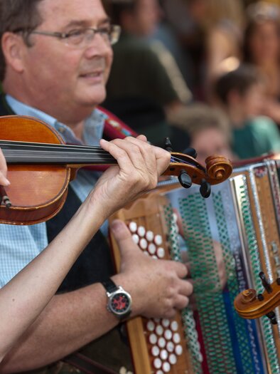 Musiker spielen im Volkshaus Köflach auf Geigen und einer steirischen Harmonika. | © Region Graz-Harry Schiffer