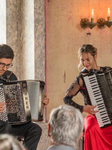 Eine Dame und ein Herr spielen auf den Akkordeons bei den Kammer Musik Festival in einem festlich, historischen Raum. | © Privat