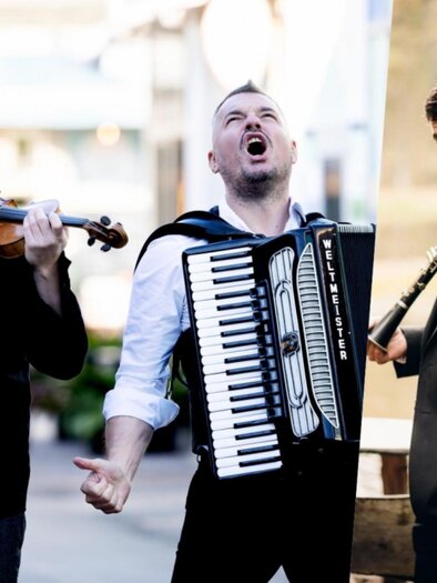 Drei Musiker mit Geige, Akkordeon und Klarinette beim Kammermusikfestival in Graz, stehen für die Aufnahme im Freien. | © Julia Wesely, Privat