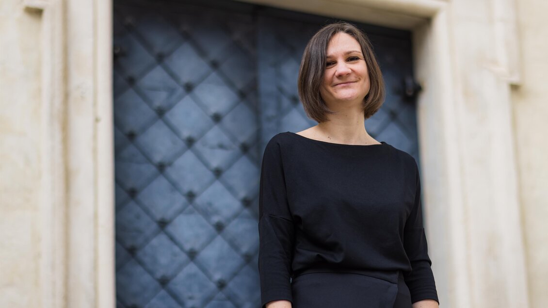 Domkapellmeisterin Melissa Dermastia vor einem alten Eingangstor | © Gerd Neuhold
