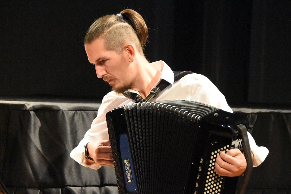 Bernd Kohlhofer spielt Akkordeon auf einer Bühne vor dunklem Hintergrund. | © Krumusik