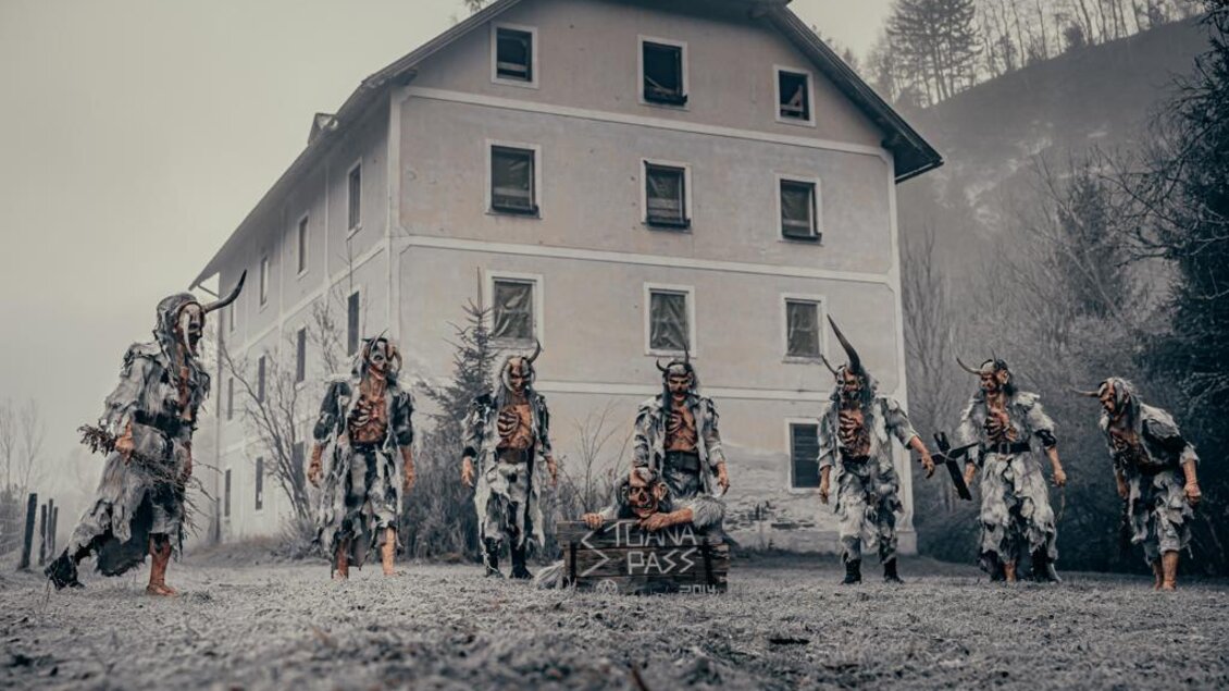 Eine gruselige Szene mit mehreren verkleideten Figuren vor einem alten, verfallenen Gebäude. Die Atmosphäre ist düster und geheimnisvoll. | © Stoana Pass