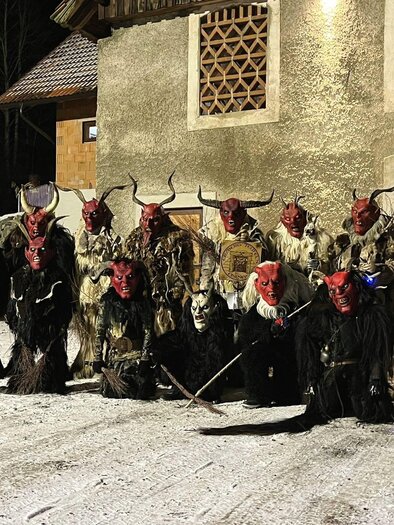 A wall with various masked heads and horns, illuminated in dark colors. The atmosphere feels eerie and mysterious. | © Erzberg Teufel'n Eisenerz