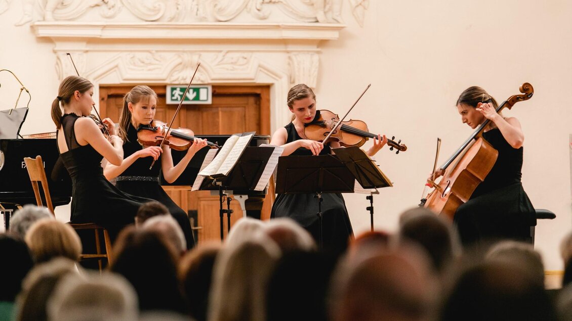 Eine talentierte Streichquartett-Performance auf einer Bühne. Die Musikerinnen tragen schwarze Kleider und spielen Instrumente vor einem begeisterten Publikum. | © Verein Neuberger Kulturtage