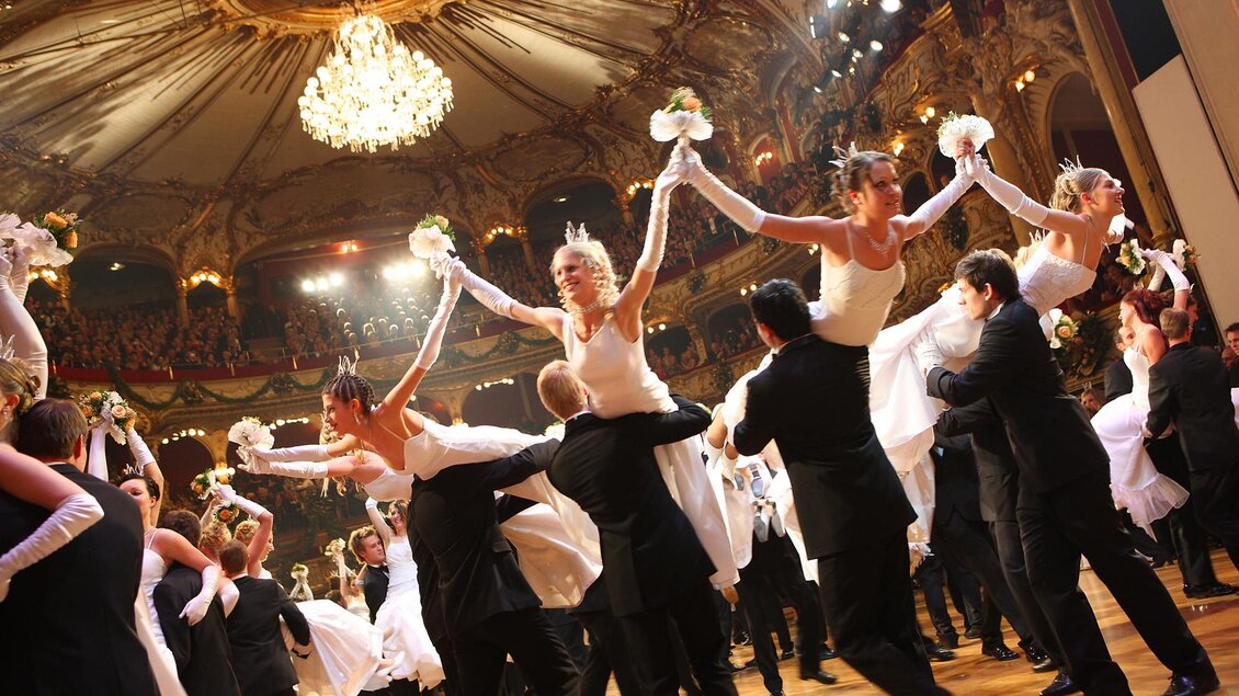Eine elegante Tanzaufführung in einem festlichen Saal. Tänzer in glamourösen Kleidern und Anzügen präsentieren eine beeindruckende Choreografie. | © Marija Kanizaj