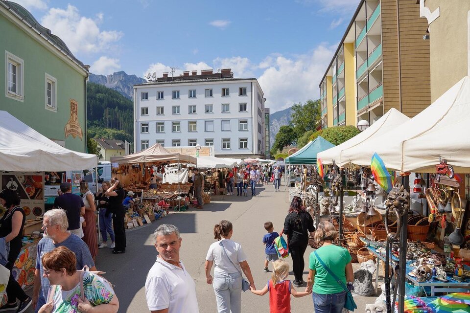 Ein belebter Markt mit vielen Ständen und Besuchern. Im Hintergrund sind Berge und mehrere Gebäude zu sehen. | © Christian Berger