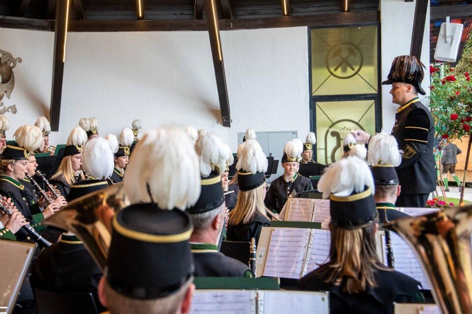 Ein Blasorchester spielt in einem festlichen Raum. Der Dirigent leitet die Musiker mit viel Enthusiasmus. | © Erich Kainzinger