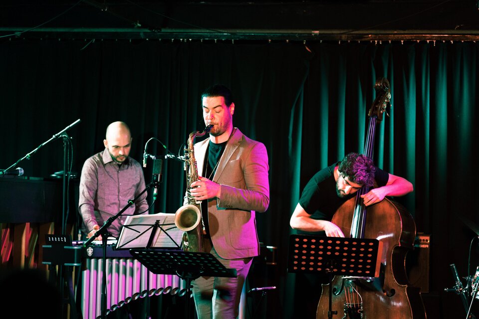 Drei Musiker spielen beim Shortcut Festival in Graz Saxofon, Vibrafon und Kontrabass auf einer beleuchteten Bühne. | © Verena Pöschl