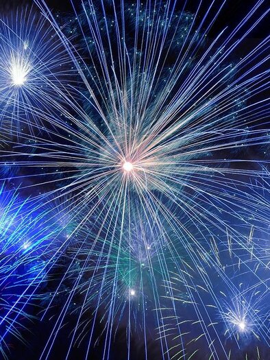 Ein spektakuläres Feuerwerk mit leuchtenden blauen und weißen Farben erhellt den Nachthimmel. Die Strahlen der Feuerwerkskörper strahlen in alle Richtungen und schaffen eine feierliche Atmosphäre. | © Pixabay.com