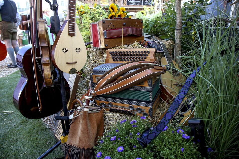 Verschiedene Instrumente der steirischen Volksmusik, darunter Harmonika, Saiteninstrumente und Kontrabass, dekorativ beim Steirischen Sänger- und Musikantentreffen in Kalsdorf arrangiert. | © Steiermark Tourismus-Michael Strobl