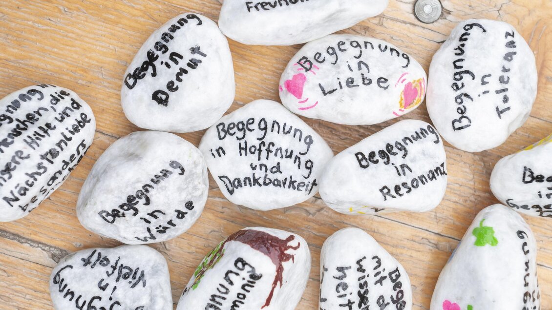 Bemalte Steine mit Sprüchen wie „Begegnung in Liebe“ und „Begegnung in Hoffnung und Dankbarkeit“ | © Fotos Fischer