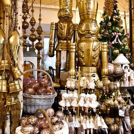 A festively decorated room with golden Christmas ornaments and figures. In the background, there is a decorated Christmas tree. | © Thermen- & Vulkanland