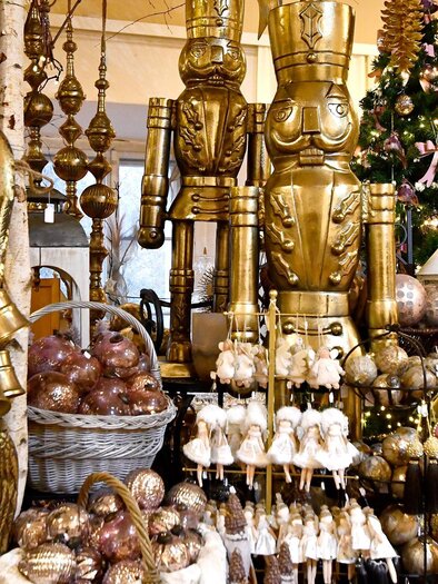 A festively decorated room with golden Christmas ornaments and figures. In the background, there is a decorated Christmas tree. | © Thermen- & Vulkanland