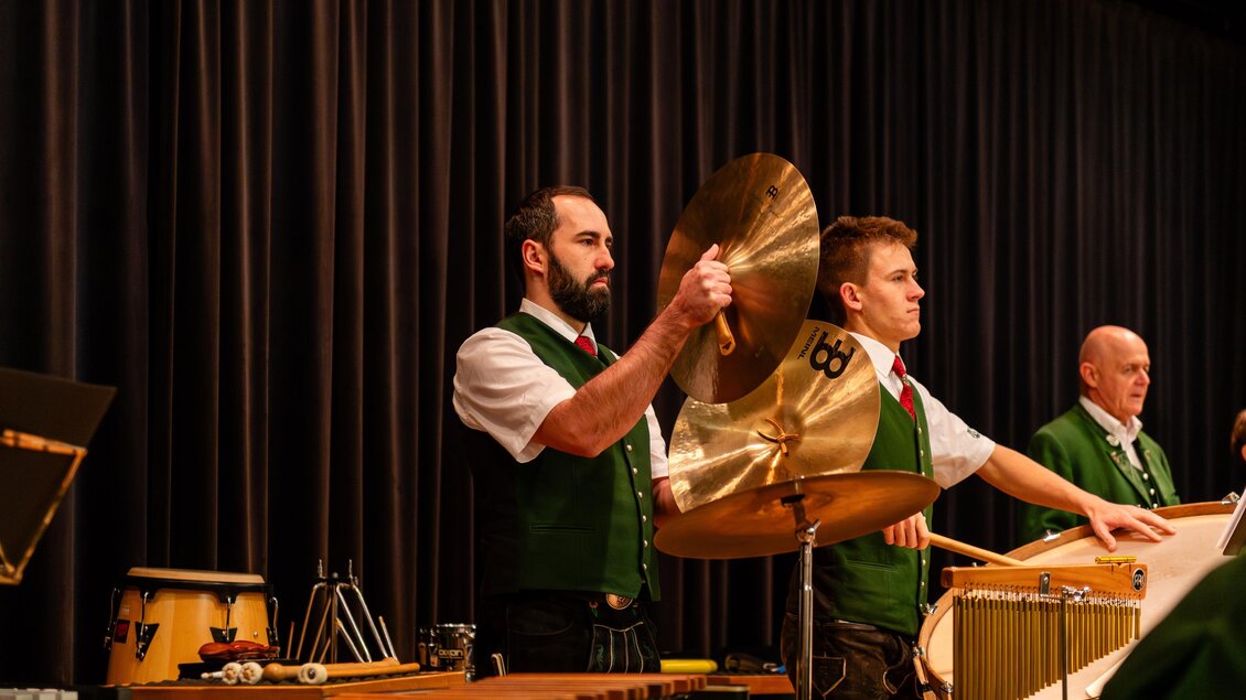 Eine Musikgruppe spielt auf der Bühne. Die Musiker tragen traditionelle Kleidung und spielen verschiedene Instrumente. | © David Stocker