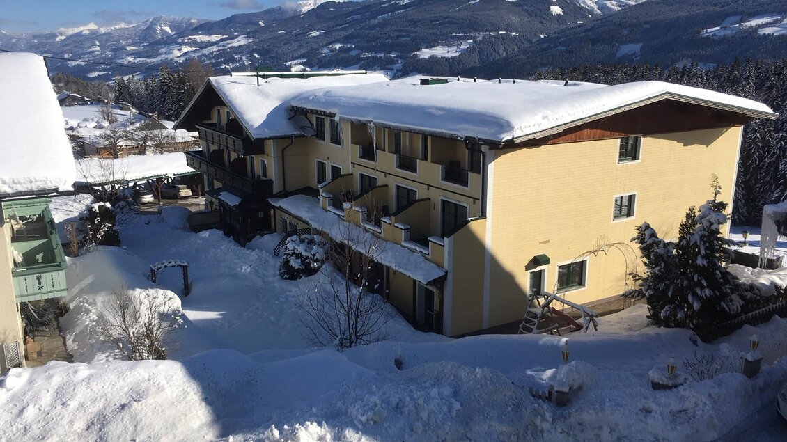 Ein schönes Hotel in einer schneebedeckten Landschaft. Die Berge im Hintergrund runden das winterliche Panorama ab. | © Hotel Martin