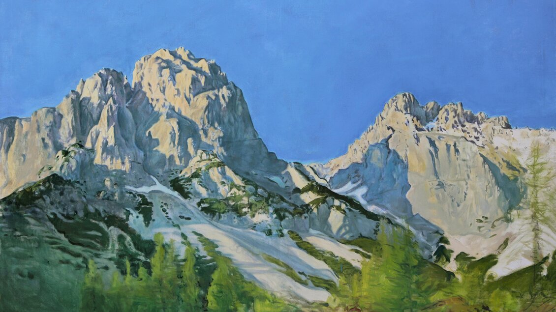 Eine beeindruckende Berglandschaft mit schneebedeckten Gipfeln und grünem Wald im Vordergrund. Der klare blaue Himmel ergänzt die majestätische Aussicht. | © Jakob Brandstätter