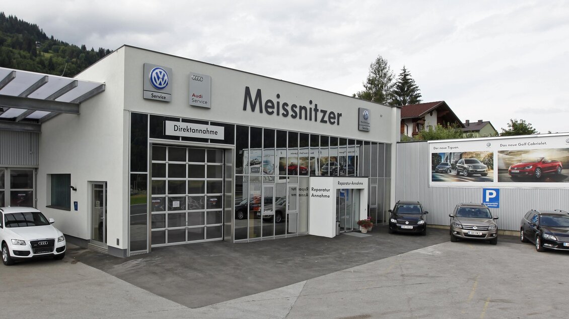Ein Autohaus mit modernen Fahrzeugen und einem klaren, einladenden Design. Die Umgebung zeigt Berge und ein grauer Himmel. | © Autohaus Meissnitzer