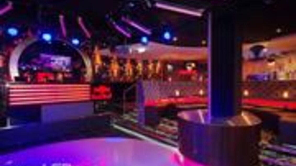 Ein modernes Nachtclub-Interieur mit bunten Lichtern und einer stilvollen Bar. Die Tanzfläche ist gut beleuchtet und lädt zum Feiern ein. | © Cultclub
