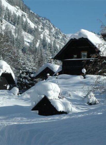 A snowy mountain village with snow-covered roofs and trees. The landscape exudes tranquility and winter magic. | © Dorfschenke