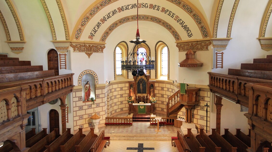 Eine schöne Kirche mit Holzbalustraden und einer großen Kuppel. Das Innere ist hell, mit bunten Fenstern und einer zentralen Altarzone. | © photo-austria.at/Hans Simonlehner