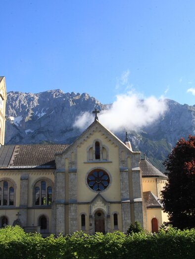 Parish church Ramsau am Dachstein against a stunning mountain panorama and blue sky. | © photo-austria/Hans Simonlehner