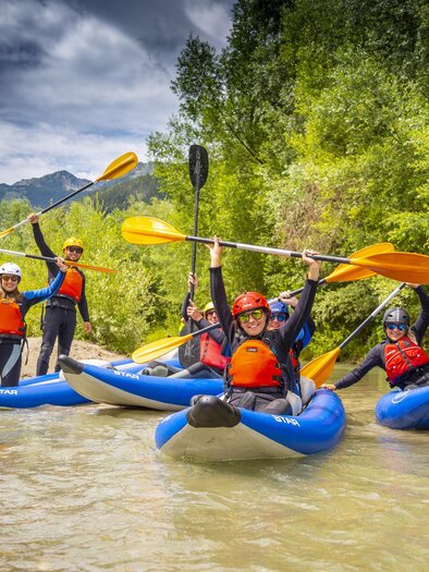 Group in the river with blue kayaks, river trekking | © Flusswandern Kajaktiv