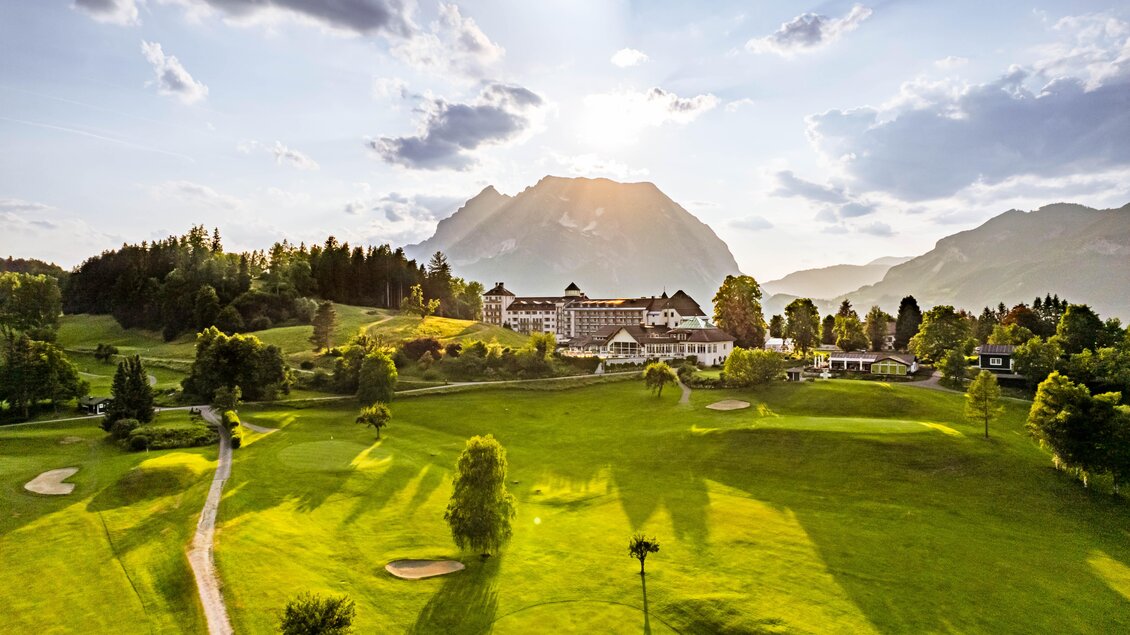 Eine malerische Golfanlage mit grünen Wiesen und sanften Hügeln. Im Hintergrund ist ein majestätischer Berg unter einem schönen Himmel zu sehen. | © Richard Schabetsberger