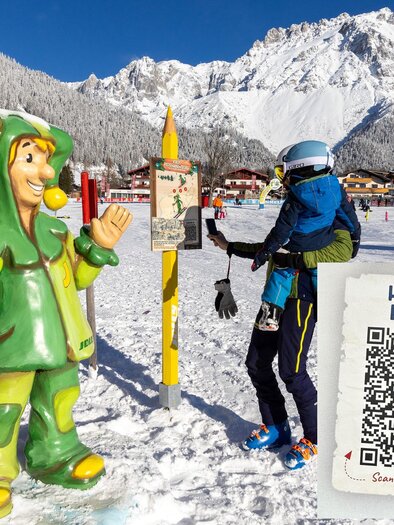 A cheerful plastic snowman stands in the snow, while a skier with a child on their back is nearby. In the background, mountains and a ski resort can be seen. | © Rittis-Lift Engelhardt GmbH &amp; Co KG