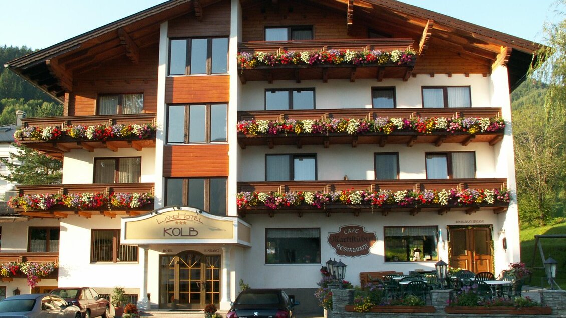 Ein gemütliches Gästehaus mit mehreren Etagen und blühenden Balkonen. Helle Fenster und ein einladender Eingangsbereich prägen die Fassade. | © Landhotel Kolb
