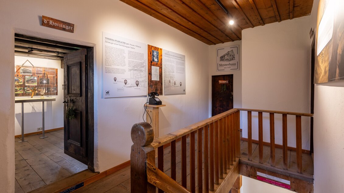 Ein heller Flur mit Holztreppe und informativen Tafeln an den Wänden. Der Raum hat eine einladende Atmosphäre und verbindet historische Elemente mit moderner Präsentation. | © Harald Steiner