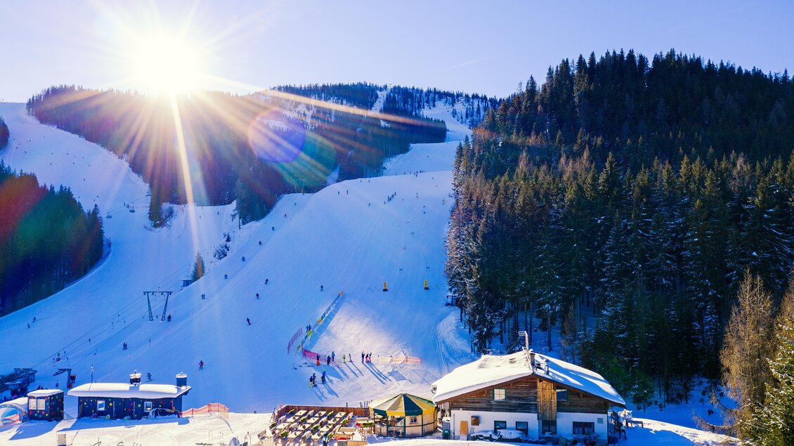 Skihütte mit Sonnenschein | © Roland Schoblocher