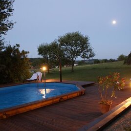 Ein Pool in einem ruhigen Garten bei Dämmerung. Der Mond scheint hell am Himmel und sorgt für eine entspannte Atmosphäre. | © Herbert Wölkart