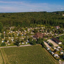 Eine Luftaufnahme eines Campingplatzes umgeben von Wäldern und Feldern. Auf dem Platz sind zahlreiche Wohnmobile und Wohnwagen zu sehen. | © Camping Steinmann