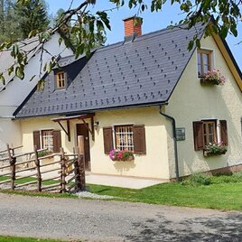 An idyllic house in the greenery with a well-kept garden. The surroundings are surrounded by trees and meadows. | © Hadn Hube