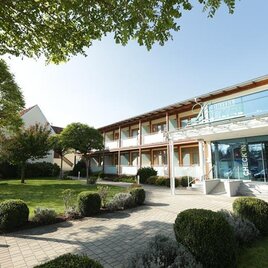 Ein modernes Hotelgebäude mit einem einladenden Eingang und schön angelegtem Garten. Die Umgebung ist grün und gepflegt, ideal für einen angenehmen Aufenthalt. | © Hotel Locker & Légere