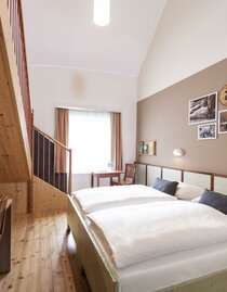 doppelbett-galeriezimmer-jufa-hotel-murau-tisch-xx | © Lenz/JUFA Hotels | Günter Lenz | © Lenz/JUFA Hotels