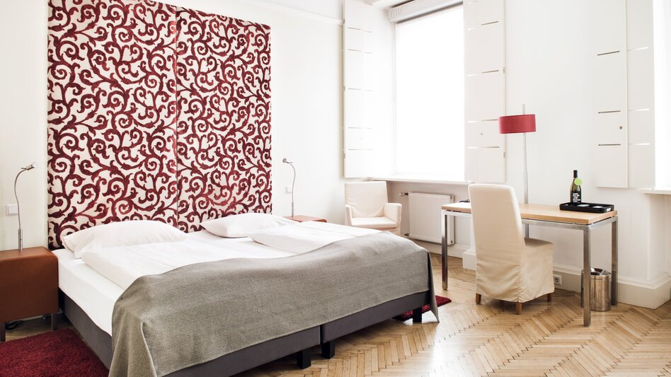 Zimmer mit Doppelbett, Tisch und Fenster. | © Weitzer