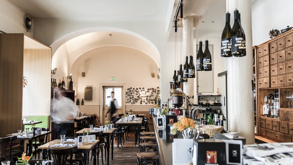 Modernes Restaurant mit Holztischen und Stühlen, Getränken und Personal in Bewegung. | © Weitzer