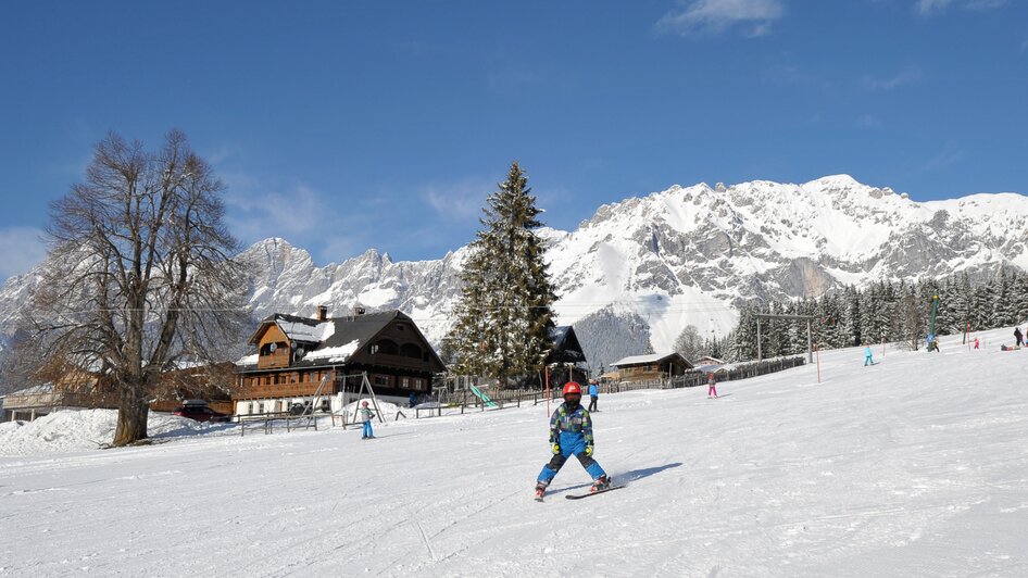 Ein Kind lernt Skifahren am Drachenlift.